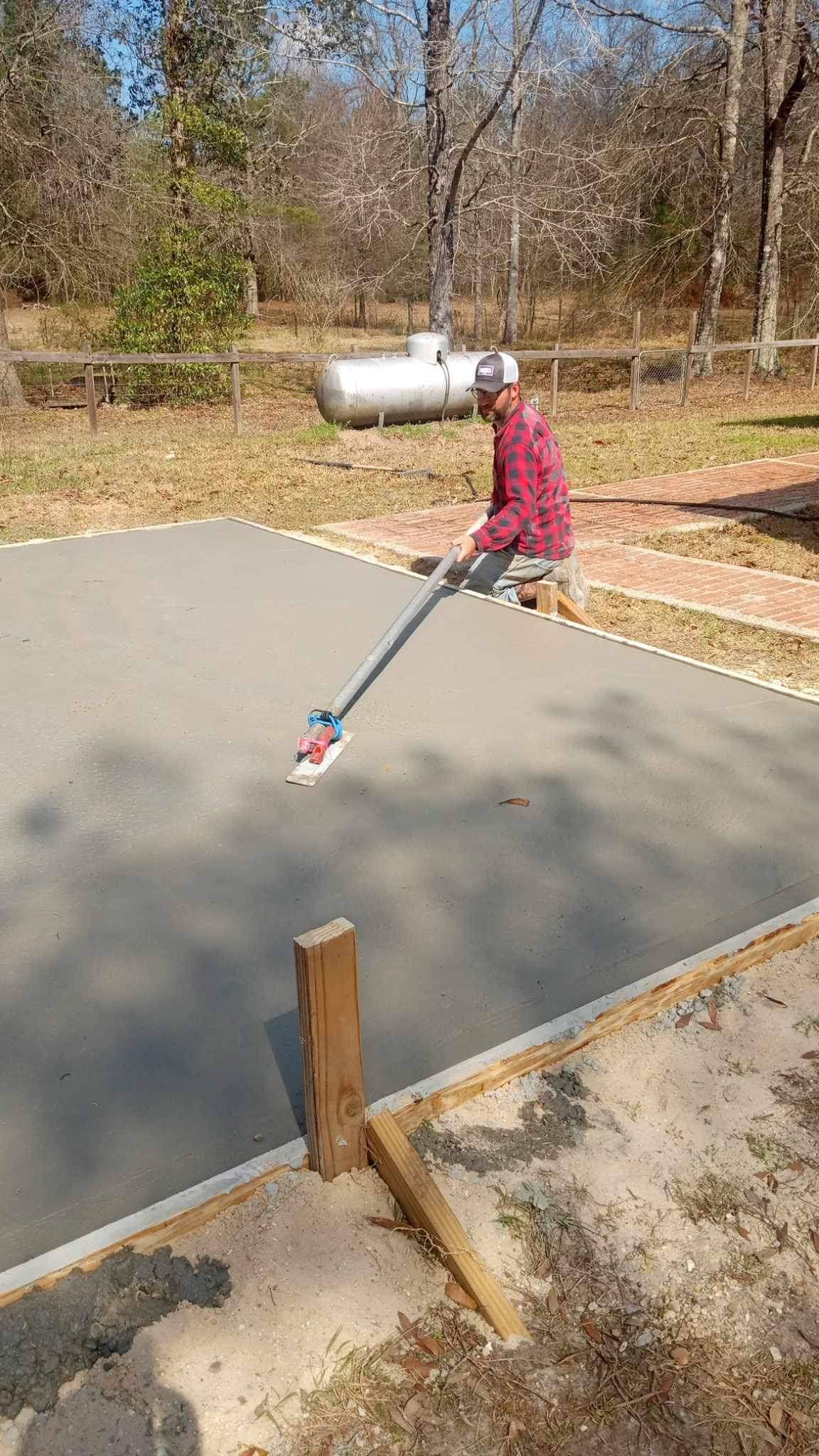 Freshly poured concrete slab being finished on site